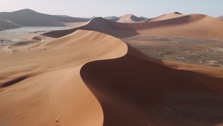 Aerial view of the iconic sand dunes of sossusvlei, namibia. Majestic desert landscape during a vibrant sunrise.