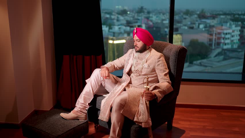 Royal Sikh Groom Sitting on Sofa with Kirpal Smiling in the Camera