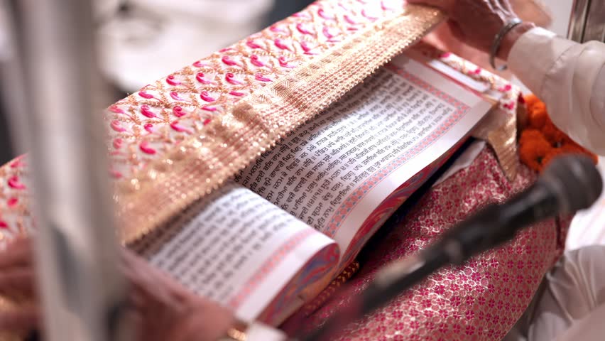Close Up of Sikh Priest Opening Guru Granth Sahib During Religious Ceremony