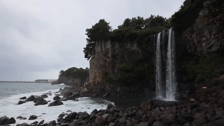 Seogwipo Jeongbang Waterfall falling in the sea Jeju islaand South Korea. TRANSLATION; JEJU