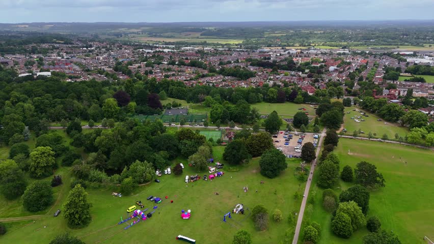 Aerial wide establishing shot of Prospect Park, Reading, UK, with people on grass