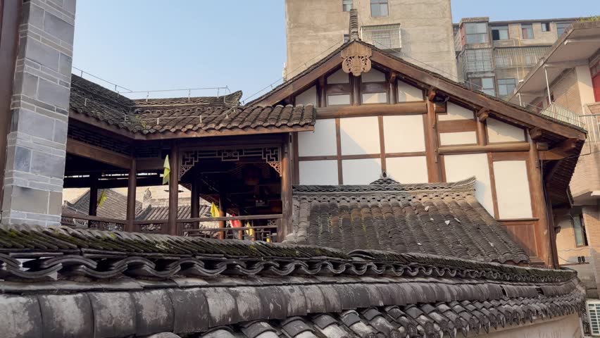 Interior courtyard of a traditional Chinese mansion featuring wooden pillars, carved balconies, and classic tiled rooftops.