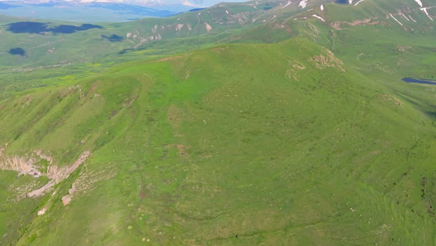 Aerial View of Rolling Green Highland Hills and Mountain Grassland