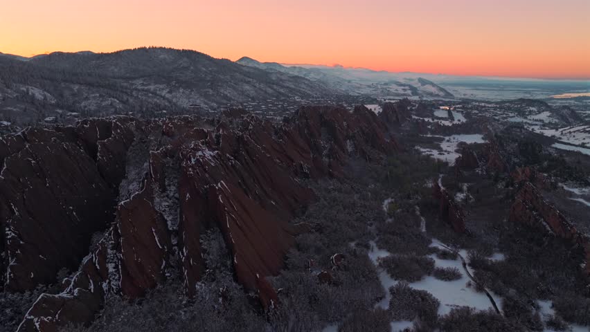 Snow-covered Roxborough State Park Fountain Valley Trail jagged red rocks sandstone Littleton Sterling Ranch Colorado aerial drone landscape vibrant sunset Denver Front Range Rocky Mountains pan left