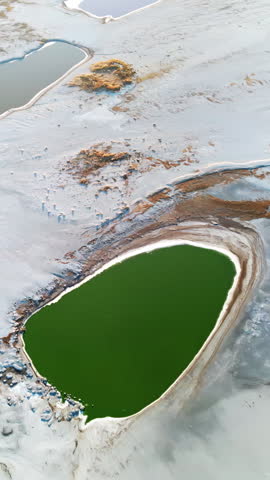 Aerial drone view of colorful salt ponds and mineral pools in a dry desert landscape in Utah, United States. Vertical
