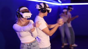 Team of couple girl and guy plays against team of two friends during virtual reality. They control characters using joysticks and are involved in course of game, VR console - Powered by Shutterstock - Get 15% off with code: PIKWIZARD15