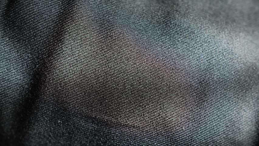 A close-up of the texture of black fabric in sunlight. Ideal for textile and fashion applications.