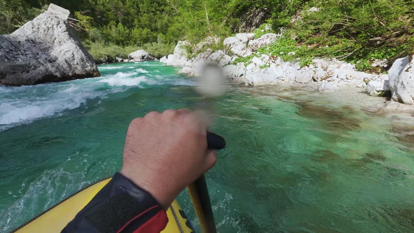 Rafting boat moves through turquoise Soca River rapids on a sunny day in Slovenia, action camera
