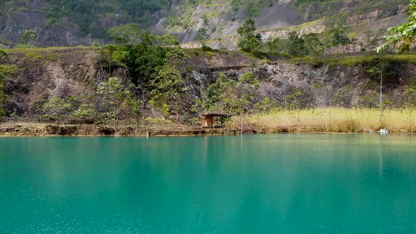 Pumping station hut and lake of water within Panguna mine pit in Bougainville, Papua New Guinea