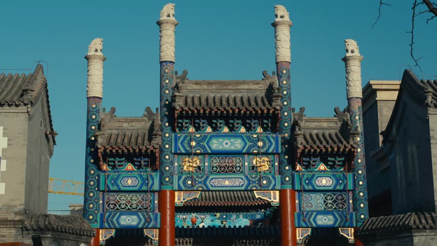 Beijing Traditional Paifang Archway with Intricate Blue and Gold Patterns and Stone Guardian Lions