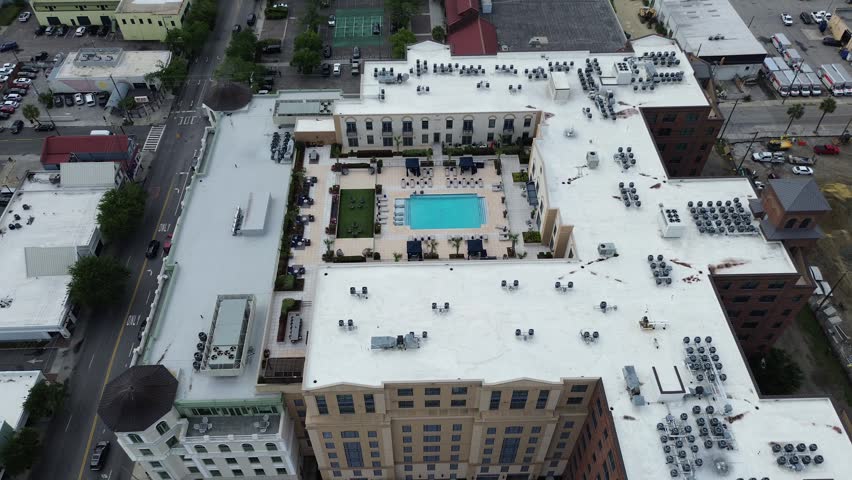Rooftop systems layout near Meeting St Lee St captures residential buildings surrounding central courtyard in Charleston Upper Peninsula. White mechanical units, pool edges form patterns, SC. USA