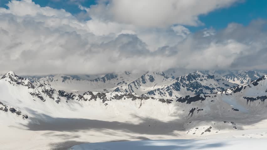 Time lapse clouds over snowy peaks beautiful mountain landscape.