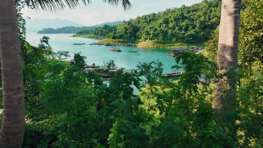 Khao sok national park lake view from boat in Thailand. Tracking shot of wooden boat bow gliding across mountain lake.