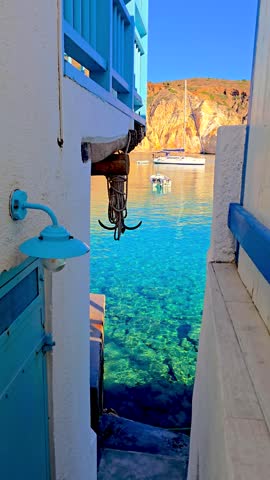 Enchanting views of Firopotamos, Milos Island in Greece, where vibrant blue waters meet stunning coastal scenery. Experience the tranquility as boats gently glide by this picturesque island