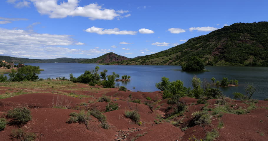 Red landscape surrounding te artificial lake of Salagou, Occitania, Southern France.