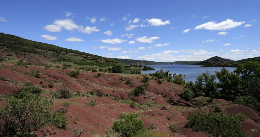 Red landscape surrounding te artificial lake of Salagou, Occitania, Southern France.