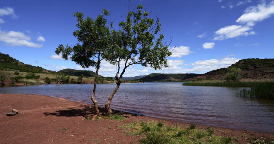 Red landscape surrounding te artificial lake of Salagou, Occitania, Southern France.