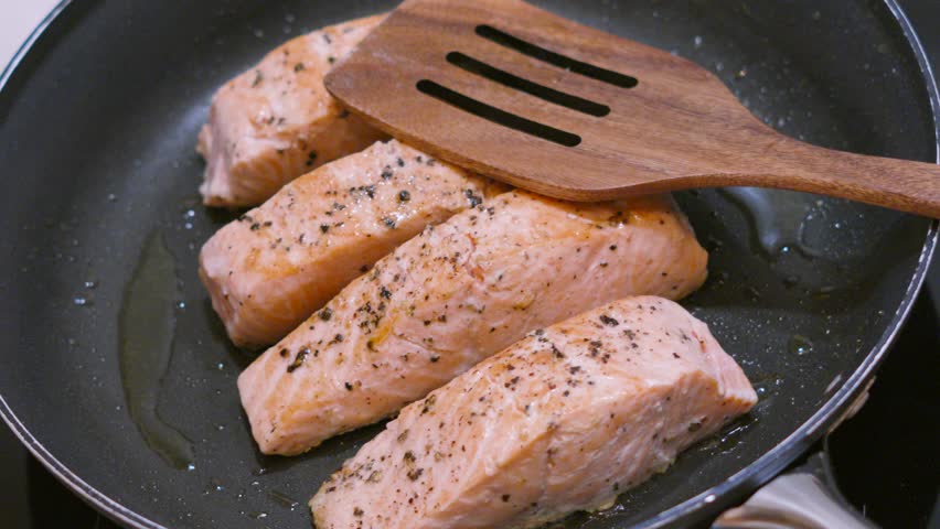 Top Down View of Seasoned Salmon Fillets with Rustic Wooden Spatula. Healthy Cooking with Fish High in Omega-3 for Healthy Lifestyle.