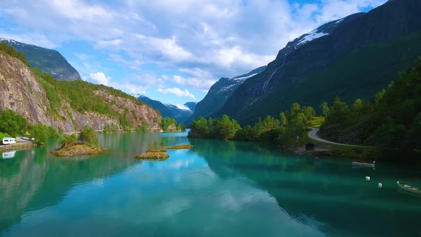 Glacial lake panorama with green water and mountain peaks.