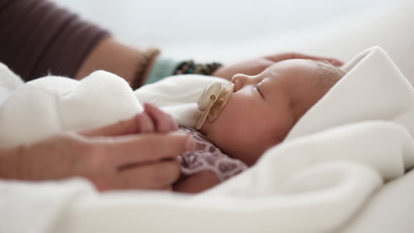 Soft Blanket Wraps Newborn Close As Mom Holds Small Hand With Care And Affection. Quiet Moment In Cozy Space.