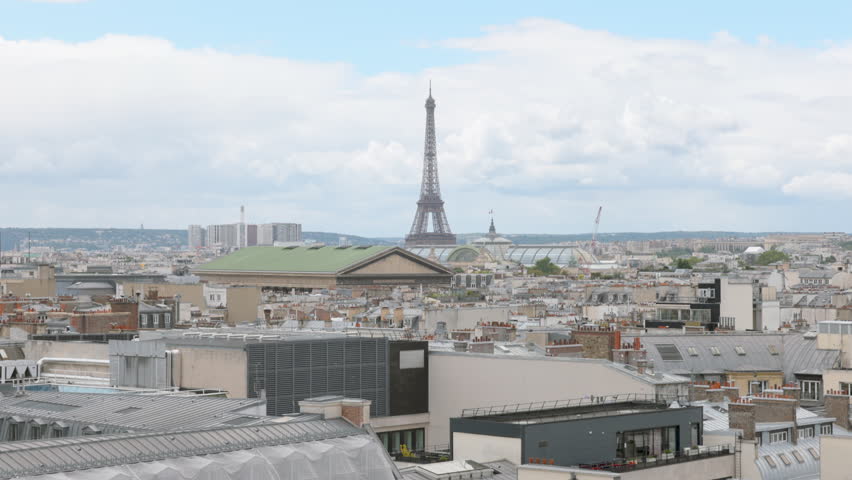 Panoramic View of Paris Skyline with Eiffel Tower and City Rooftops under Cloudy Sky