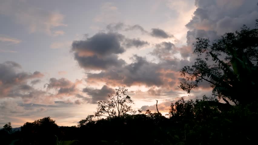 Gathering of stormy clouds over the farms and forest, at sunset, time lapse shot in the eastern Andean mountains of central Colombia, near the Iguaque natural reserve.