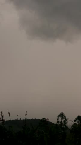 Gathering of stormy clouds over the farms and forest, at sunset, time lapse shot in the eastern Andean mountains of central Colombia, near the Iguaque natural reserve.