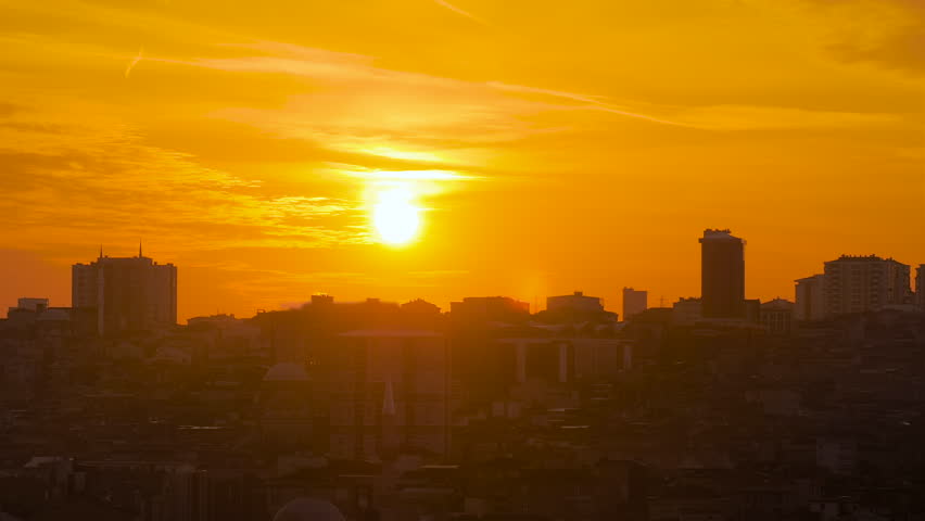 Time lapse: amazing sunset sky with the setting sun over the city of Istanbul, Turkey in the evening: apartment, residential buildings silhouettes, getting darker. Timelapse and cityscape concept