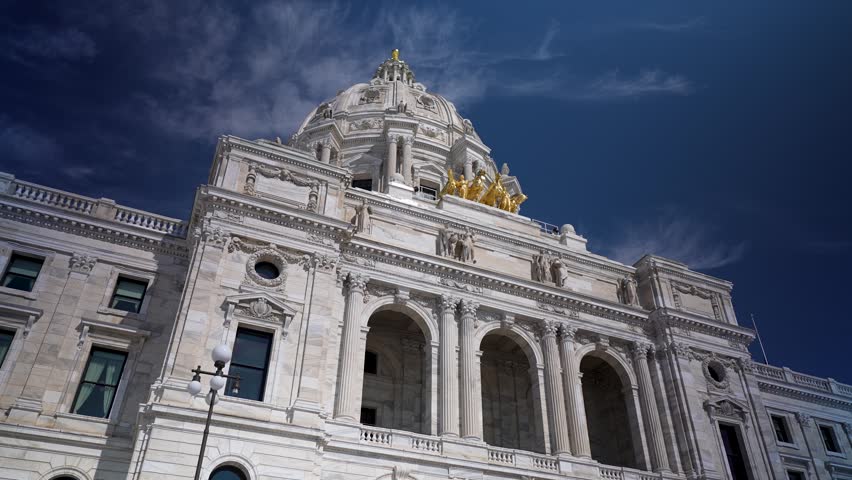 Sunlight bathes the Minnesota state Capitol in Saint Paul while showing its majestic architecture and blue sky on a clear day.
