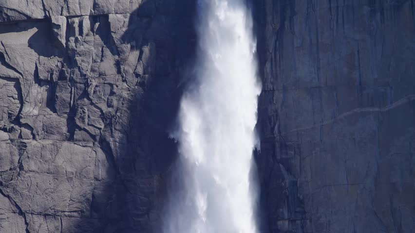 Tilt down extreme close up of Upper Yosemite Falls as water plunges over the edge in Yosemite National Park, California.