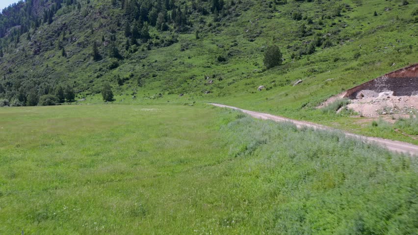 SUV driving on dirt road through green hills, open valley, off road travel adventure with freedom, exploration, remote countryside journey in natural landscape. car driving dirt road off road travel