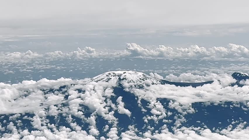 Aerial view of Mount Kilimanjaro snow capped peak above the clouds in Tanzania