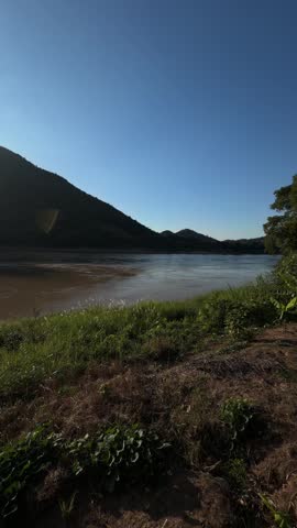 Scenic sunburst over mountain and river landscape