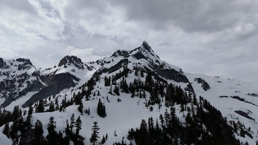 Majestic Snow-Capped Mountains and Evergreen Forests in British Columbia, Canada on a Cloudy Day