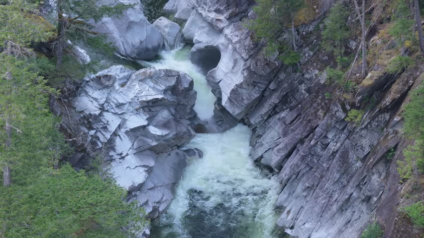 Powerful Waterfall and Rushing River Flowing Through a Rocky Canyon in British Columbia, Canada