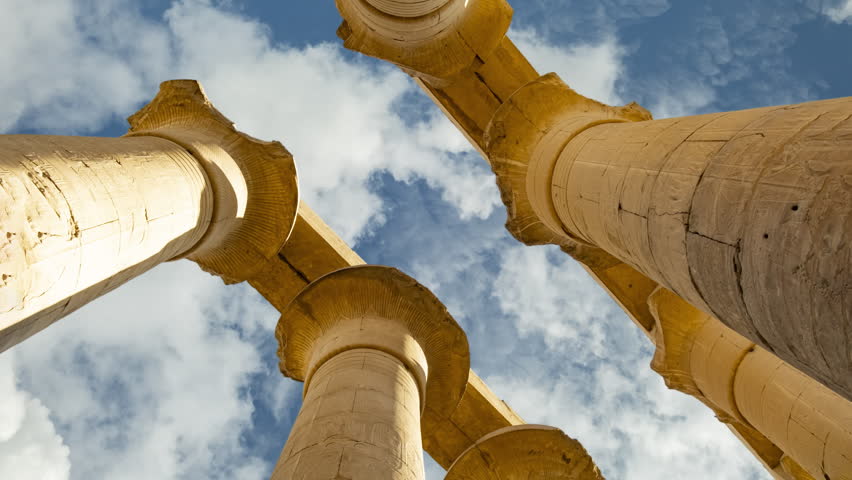 Timelapse of white clouds on blue sky over Ancient Egypt Papyrus columns of the Great Hypostyle Hall in Karnak temple Luxor, Egypt