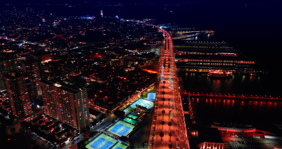 Beautifully lit quay and luminous piers. Descend over the waterfront of San Francisco, California, USA at night.