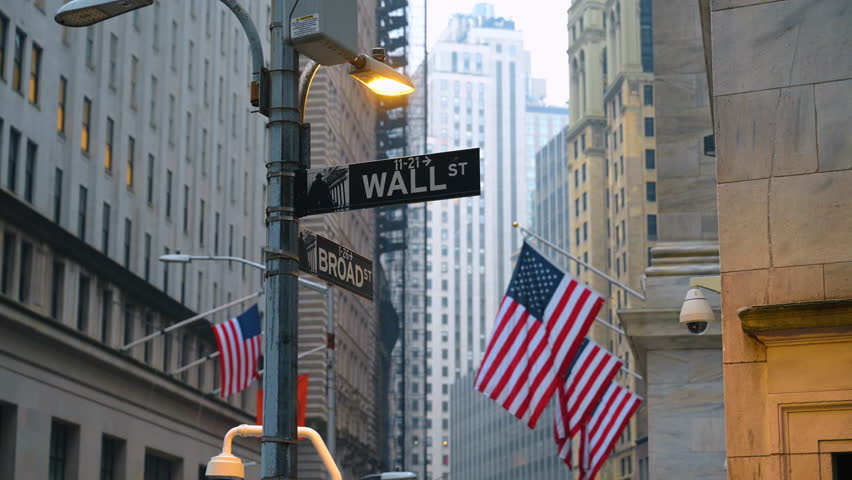 New York, USA, 5 October 2025 : Road signs directing to Wall Street and Broad Street in New York, USA. American flags hang on the facades of the buildings at backdrop.