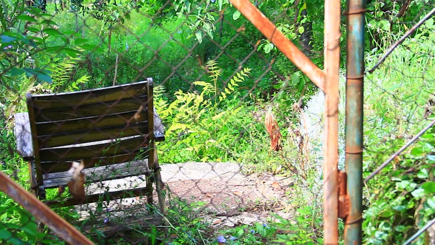 Old chair behind the rusty fence.