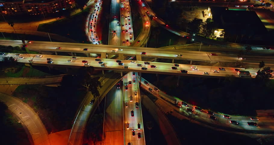 Approaching the lively interchange with switched on illumination at night. Intersection in modern Los Angeles, California, USA.