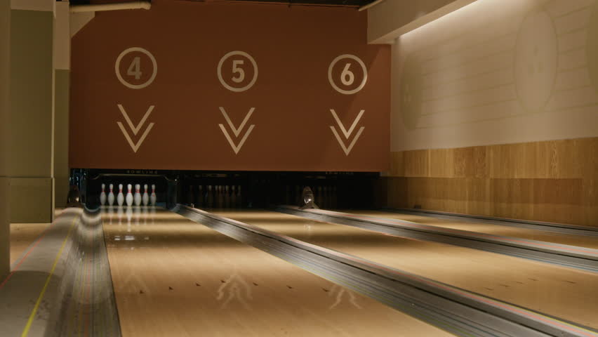 Full shot of sets of pins set up in lanes in bowling alley for game or tournament. Footage is ideal for sports bar promotions, recreational center advertisements, or leisure lifestyle content