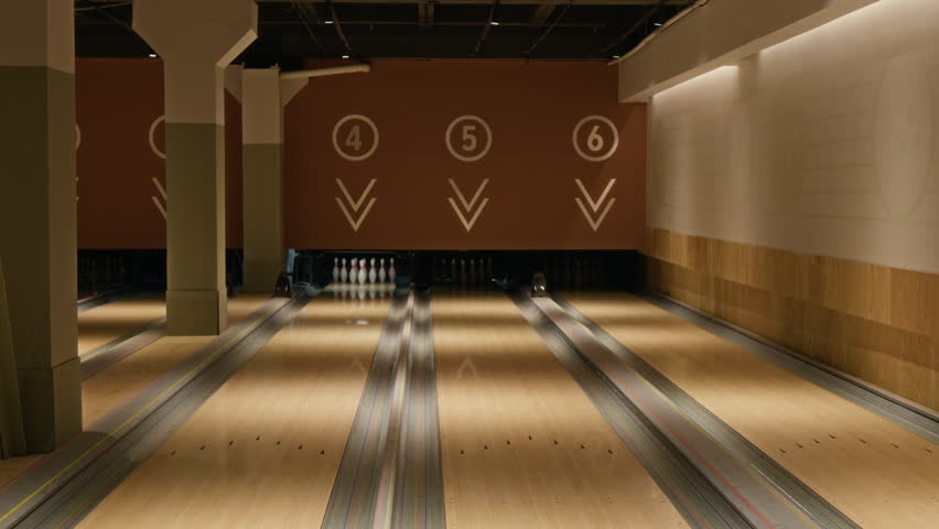Empty bowling lanes sitting ready with pins set up in modern entertainment center. Ideal for promoting family weekend activities, corporate events, or local recreational sports leagues