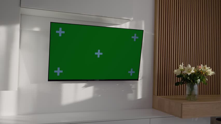 A living room setup with a green screen television is shown. The screen is ready for editing and adding custom backgrounds for different projects.