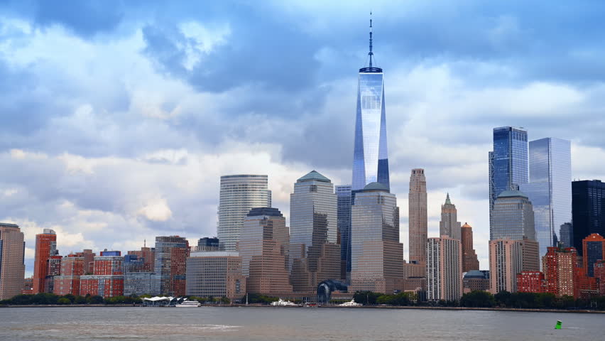 New York skyline from the waterscape view. One World Trade Center stands out from the scenery. Cloudy sky at backdrop.
