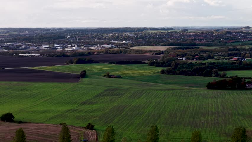 Farmlands stretching across Jutland countryside with fields and trees.
