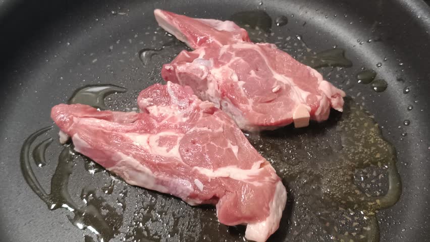 lamb chops cooking in a pan