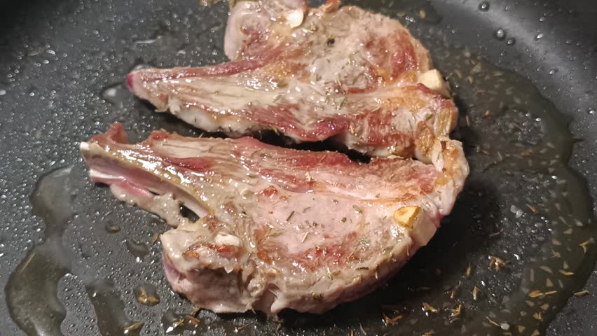 lamb chops cooking in a pan