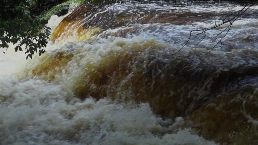 turbulent brown waters in the rapids, close view