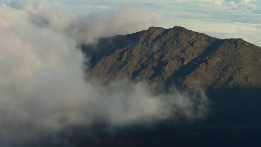 Rugged Mountain Peak Shrouded In Dense, White Clouds In Haleakala National Park on Maui, Hawaii. - wide shot