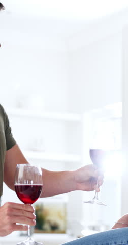 Hands, couple and cheers with red wine in kitchen for anniversary, marriage celebration or kiss. Flare, happy people and alcohol toast in home for relationship growth, bonding together and connection